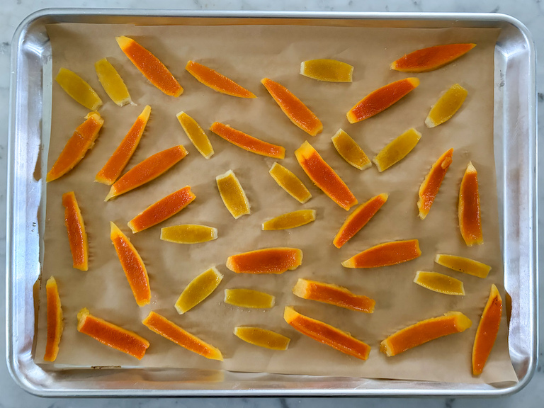 citrus peel slices on a parchment lined tray