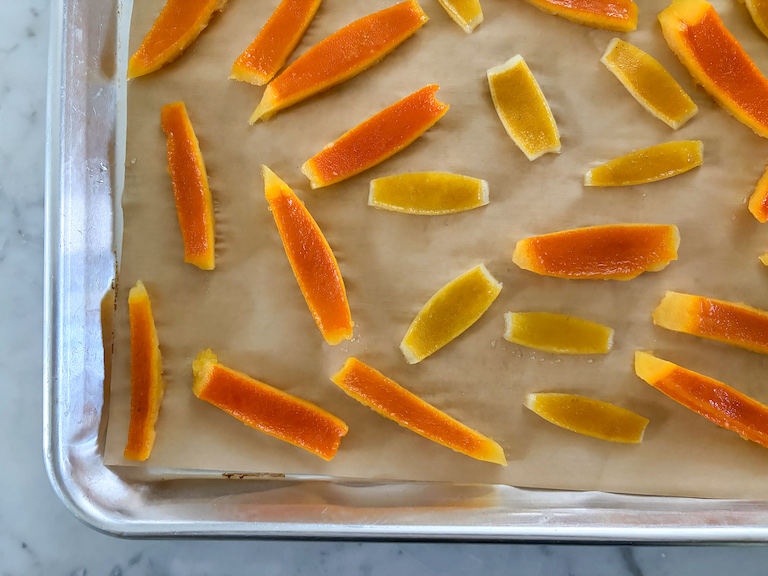 orange and lemon peels drying on a sheet of parchment
